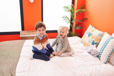 Photo for Adorable boy and girl smiling confident sitting on bed at bedroom - Royalty Free Image