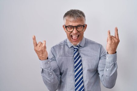 Photo for Hispanic business man with grey hair wearing glasses shouting with crazy expression doing rock symbol with hands up. music star. heavy music concept. - Royalty Free Image