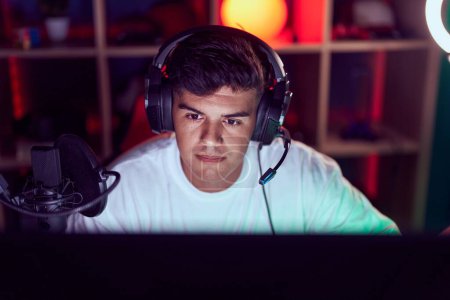 Photo for Young hispanic man streamer playing video game using computer at gaming room - Royalty Free Image
