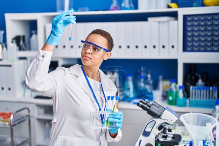 Foto de Mujer científica afroamericana sosteniendo tubos de ensayo en laboratorio - Imagen libre de derechos