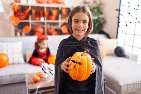 Photo for Adorable boy and girl having halloween party holding pumpkin at home - Royalty Free Image