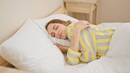 Téléchargez les photos : Jeune femme blonde couchée sur le lit dormant dans la chambre - en image libre de droit