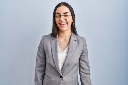 Foto de Mujer de negocios hispana con gafas guiñando el ojo mirando a la cámara con expresión sexy, cara alegre y feliz. - Imagen libre de derechos