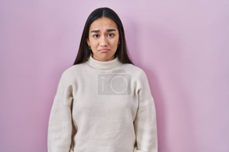 Photo for Young south asian woman standing over pink background depressed and worry for distress, crying angry and afraid. sad expression. - Royalty Free Image
