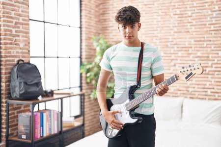 Photo for Young hispanic teenager musician playing electrical guitar at bedroom - Royalty Free Image