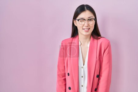 Téléchargez les photos : Chinois entreprise jeune femme portant des lunettes clin d'oeil en regardant la caméra avec une expression sexy, gai et heureux visage. - en image libre de droit