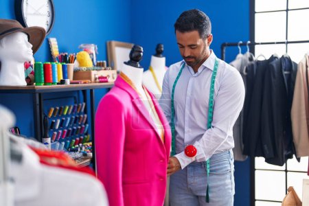 Téléchargez les photos : Jeune homme hispanique tailleur veste de mesure au studio de couture - en image libre de droit