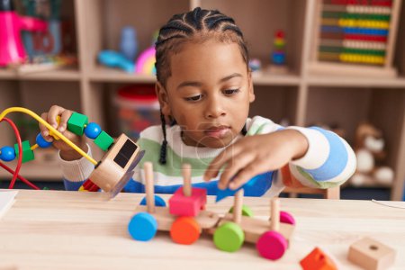 Photo for African american boy playing with blocks train toy sitting on table at kindergarten - Royalty Free Image