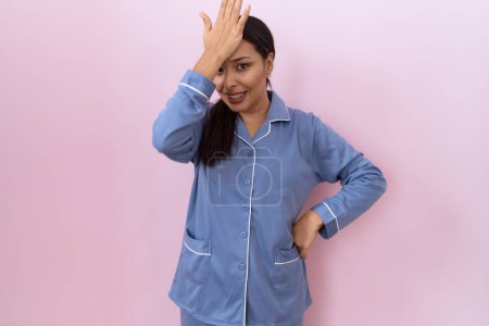 Foto de Mujer árabe joven con pijama azul sorprendido con la mano en la cabeza por error, recordar el error. olvidado, mal concepto de memoria. - Imagen libre de derechos