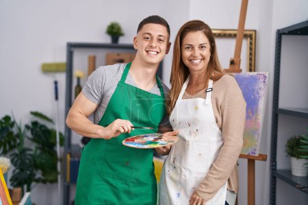 Téléchargez les photos : Artistes hommes et femmes souriants confiants tenant pinceau et palette au studio d'art - en image libre de droit