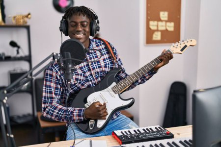 Téléchargez les photos : Musicien afro-américain chantant une chanson jouant de la guitare électrique au studio de musique - en image libre de droit