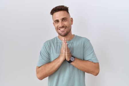 Photo for Hispanic man with beard standing over white background praying with hands together asking for forgiveness smiling confident. - Royalty Free Image