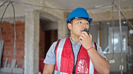 Téléchargez les photos : Constructeur parler sur talkie walkie sur le chantier de construction - en image libre de droit