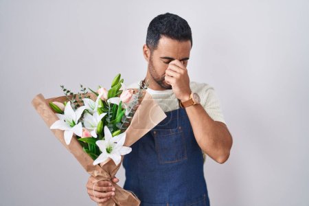 Téléchargez les photos : Homme hispanique avec la barbe travaillant comme fleuriste fatigué se frottant le nez et les yeux ressentant fatigue et maux de tête. concept de stress et de frustration. - en image libre de droit