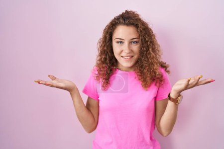 Photo for Young caucasian woman standing over pink background smiling cheerful offering hands giving assistance and acceptance. - Royalty Free Image