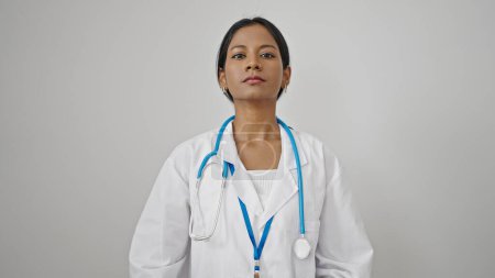 Téléchargez les photos : Femme afro-américaine médecin debout avec une expression sérieuse sur fond blanc isolé - en image libre de droit