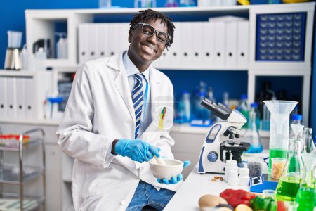 Photo for African american man scientist smiling confident mixing sample at laboratory - Royalty Free Image