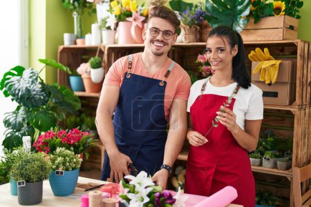 Photo for Man and woman florists cutting flowers at flower shop - Royalty Free Image