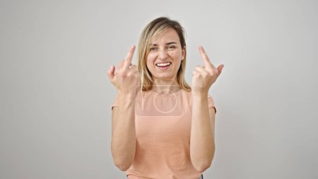 Photo for Young blonde woman doing bad gesture with fingers over isolated white background - Royalty Free Image