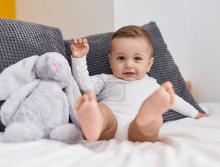 Photo for Adorable caucasian baby smiling confident sitting on bed at bedroom - Royalty Free Image