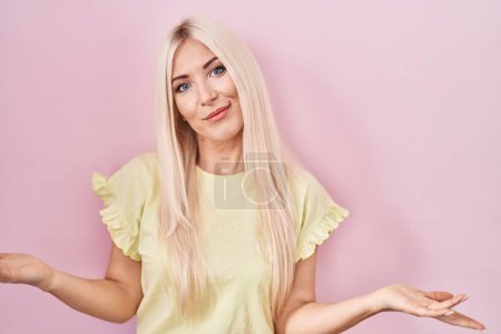 Photo for Caucasian woman standing over pink background clueless and confused with open arms, no idea concept. - Royalty Free Image