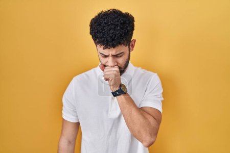 Téléchargez les photos : Homme arabe debout sur fond jaune se sentant mal et toussant comme symptôme de rhume ou de bronchite. concept de soins de santé. - en image libre de droit