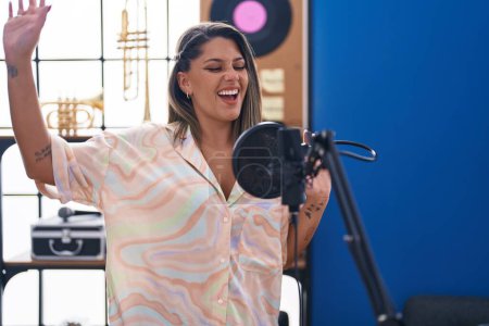 Téléchargez les photos : Young hispanic woman artist singing song at music studio - en image libre de droit
