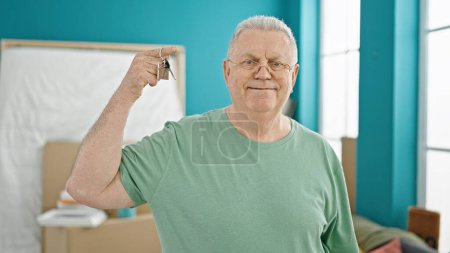 Photo for Middle age grey-haired man smiling confident holding keys at new home - Royalty Free Image