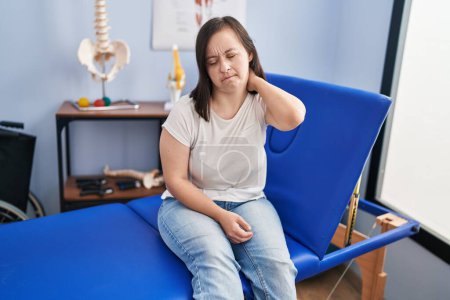 Foto de Síndrome de Down mujer fisioterapia paciente que sufre de lesión en el cuello en la clínica fisioterapeuta - Imagen libre de derechos