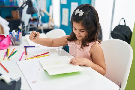 Téléchargez les photos : Adorable hispanique fille étudiant écriture sur ordinateur portable à la salle de classe - en image libre de droit