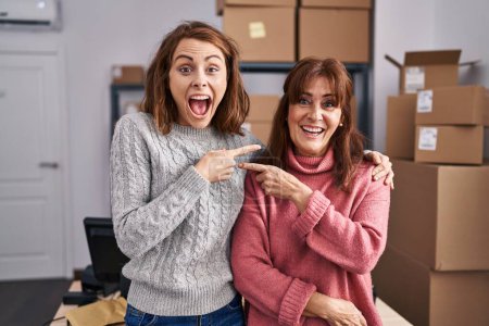 Téléchargez les photos : Deux femmes travaillant dans une petite entreprise e-commerce souriant heureux pointant avec la main et le doigt - en image libre de droit