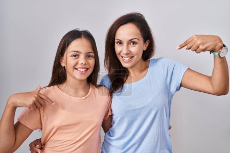 Photo for Young mother and daughter standing over white background looking confident with smile on face, pointing oneself with fingers proud and happy. - Royalty Free Image