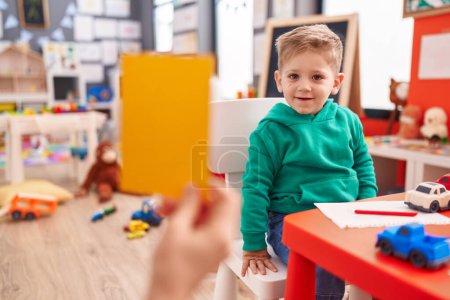 Foto de Adorable chico caucásico teniendo lección de vocabulario en el jardín de infantes - Imagen libre de derechos