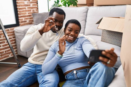 Téléchargez les photos : Homme et femme couple ayant la clé de tenue d'appel vidéo à la nouvelle maison - en image libre de droit