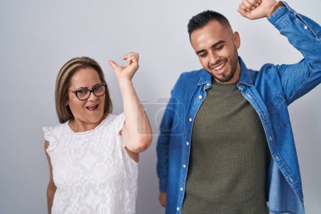 Photo for Hispanic mother and son standing together dancing happy and cheerful, smiling moving casual and confident listening to music - Royalty Free Image
