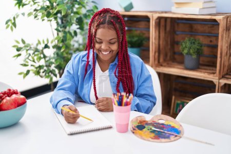 Téléchargez les photos : African american woman artist smiling confident drawing on notebook at home - en image libre de droit