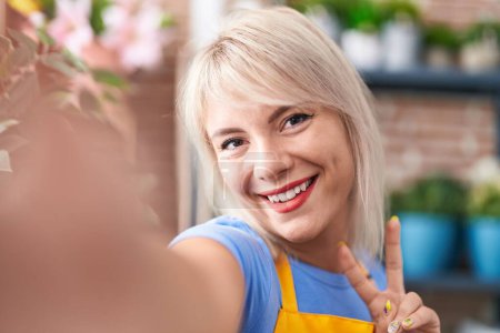 Photo for Young blonde woman florist smiling confident make selfie by camera at florist - Royalty Free Image