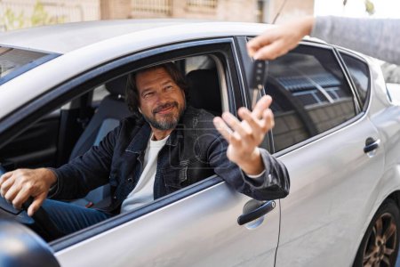 Téléchargez les photos : Moyen Age homme souriant confiant tenant la clé de nouvelle voiture à la rue - en image libre de droit