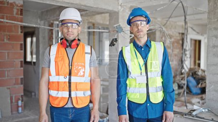 Photo for Two men builders standing together with relaxed expression at construction site - Royalty Free Image