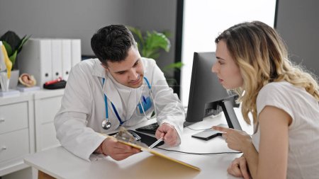 Photo for Man and woman doctor and patient having consultation showing medical report at clinic - Royalty Free Image