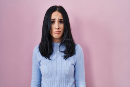 Photo for Hispanic woman standing over pink background depressed and worry for distress, crying angry and afraid. sad expression. - Royalty Free Image