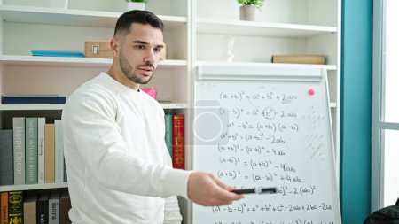 Téléchargez les photos : Jeune homme hispanique professeur d'enseignement des mathématiques leçon à la bibliothèque de l'université - en image libre de droit