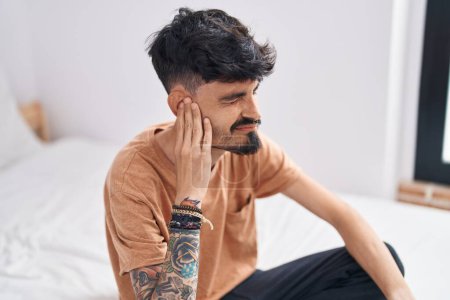 Téléchargez les photos : Jeune homme hispanique souffrant de douleur à l'oreille dans la chambre - en image libre de droit