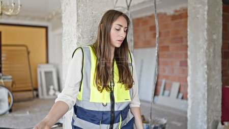 Photo for Young beautiful hispanic woman builder standing tired at construction site - Royalty Free Image