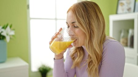 Photo for Young beautiful hispanic woman drinking juice at dinning room - Royalty Free Image