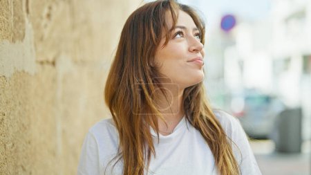 Photo for Young beautiful hispanic woman smiling confident looking to the sky at street - Royalty Free Image