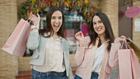 Foto de Dos mujeres cliente sosteniendo bolsas de compras y tarjeta de crédito en la calle - Imagen libre de derechos