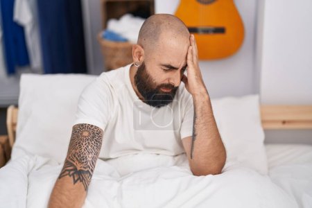Téléchargez les photos : Young bald man stressed sitting on bed at bedroom - en image libre de droit