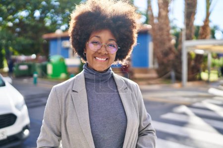 Foto de Mujer afroamericana ejecutiva sonriendo confiada de pie en la calle - Imagen libre de derechos