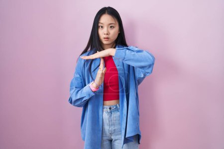 Téléchargez les photos : Jeune femme asiatique debout sur fond rose faisant un geste avec les mains, frustré et sérieux visage - en image libre de droit